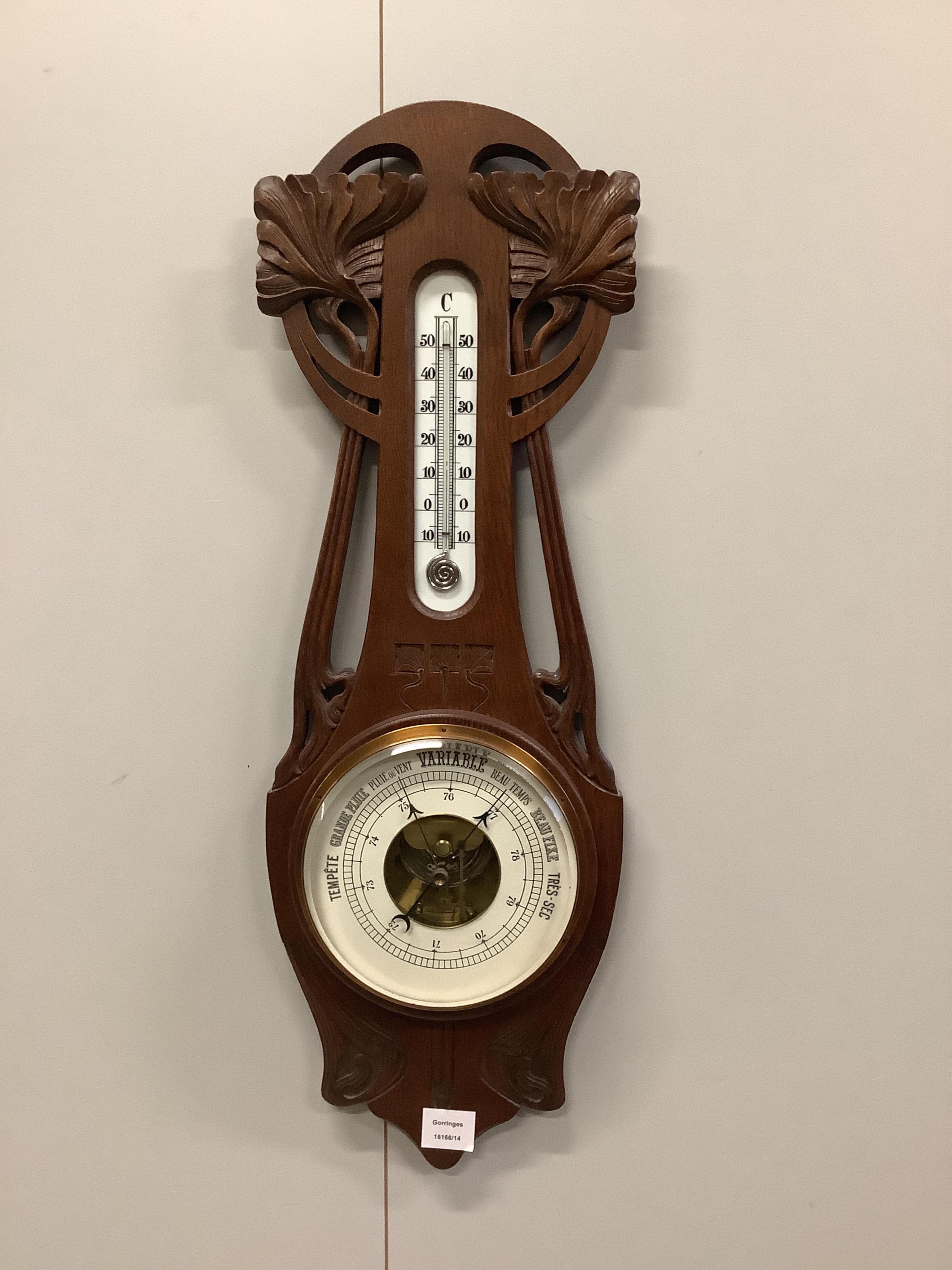 A late 19th century French Art Nouveau carved oak aneroid barometer and thermometer, height 76cm. Condition - fair to good